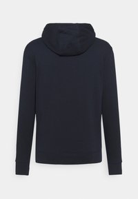 Sudadera azul marino hecha de una suave mezcla de algodón, con capucha de cordón en contraste y puños acanalados. Diseño simple y sin costuras, sin logotipos visibles.