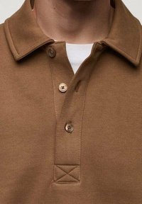 Braunes Poloshirt aus strukturiertem Stoff, mit einem klassischen Kragen, drei Knöpfen und einem gestickten Akzentdetail am Saum.