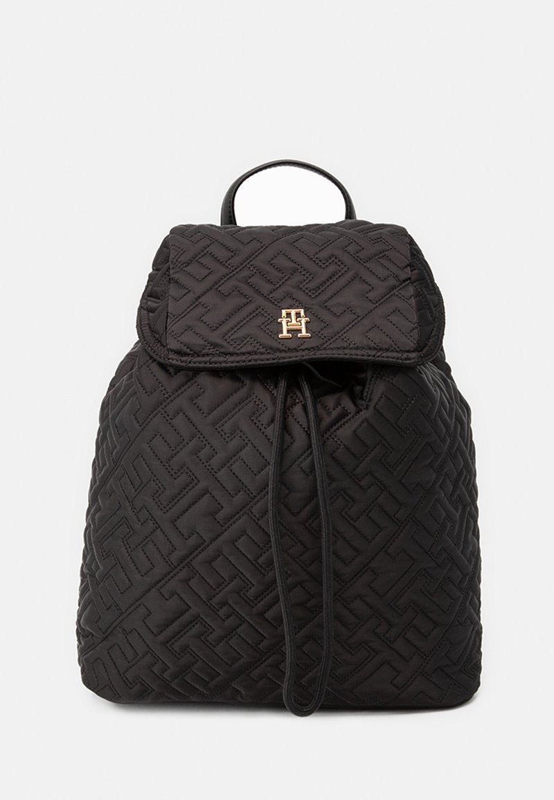 Sac à dos matelassé noir à motif géométrique, logo double T doré sur le rabat, fermeture par cordon et poignée supérieure.