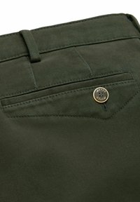 Pantalons vert olive avec une texture côtelée subtile, poche arrière avec un bouton décoratif en or et coutures renforcées.