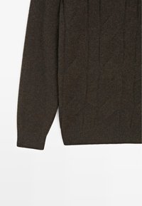 Maglione marrone scuro lavorato a maglia con motivo a trecce, polsini e orlo a costine. Realizzato in filato morbido e strutturato. Adatto per un abbigliamento casual.