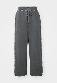 Šedé tepláky s volným střihem, s elastickým pasem, stahovací šňůrkou a bočními kapsami. Texturovaná látka s ladícími bočními detaily.