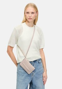 Hellbeige Umhängetasche aus glattem Leder, mit rechteckiger Form, minimalistischem Design und einem dezenten tonalen Akzent auf der Vorderseite.