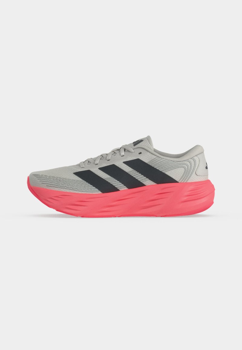 Zapatilla de correr gris claro con rayas negras y suela gruesa de color rosa brillante, mostrada de perfil sobre fondo blanco.