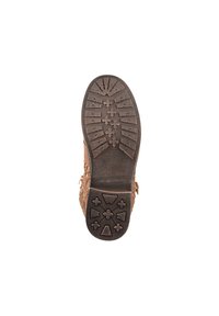 Botte en cuir marron avec des découpes élaborées sur les côtés. Semelle en caoutchouc texturé avec des motifs de traction multidirectionnels pour une bonne adhérence.