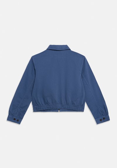 Πίσω όψη μπλε μακρυμάνικου μπουφάν με κουμπωτά μανίκια, επίπεδη γιακά και ελαστική μέση σε απλό φόντο.