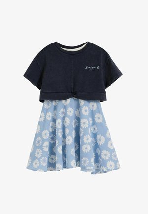 Top corto a maniche corte color navy con piccola scritta bianca abbinato a gonna azzurro chiaro al ginocchio con motivo floreale bianco.