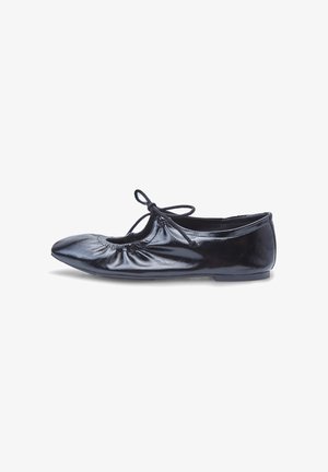 Ballerine noire en cuir brillant, avec un bout rond, un tissu froncé à l'avant et un accent nœud sur le dessus.