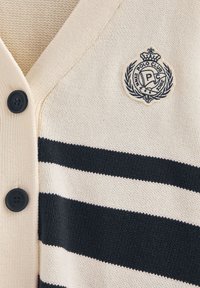 Cremfarbener Cardigan mit marineblauen Streifen, versehen mit einem V-Ausschnitt, strukturiertem Strick und schwarzen Knöpfen. Enthält ein kreisförmig gesticktes Logo.