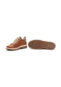 Chaussures en cuir marron avec une surface texturée, des accents beige contrastants, des lacets blancs et une semelle en caoutchouc robuste et à motifs.