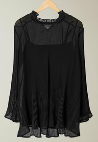 Schwarze, durchsichtige Bluse mit horizontalen Falten, einem Rüschenausschnitt und langen, ausgestellten Ärmeln, präsentiert an einem Holzkleiderbügel.