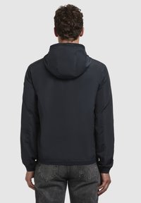Marineblaues Kapuzenjackett aus glattem, leichtem Stoff, mit elastischen Bündchen und Saum, das ein minimalistisches Design ohne sichtbare Logos aufweist.