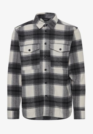 Zwart-wit geblokt flanellen shirt met een geruit patroon, knoopsluiting bij de kraag, twee borstzakken en zwarte knopen op een recht afgesneden zoom.