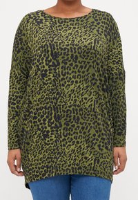 Grön djurmönstrad långärmad topp med rundad halsringning, med en lös passform och mjuk textur, som är ihop med blå denim.