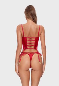 Czerwony satynowy gorset z regulowanymi ramiączkami, koronkowymi akcentami i złotymi elementami. Posiada wycięty tył oraz stringi z pasami do pończoch.