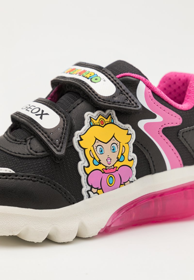 Zapatillas negras con acentos rosas, correas de Velcro, con un diseño de personaje de la Princesa Peach; suela translúcida rosa.