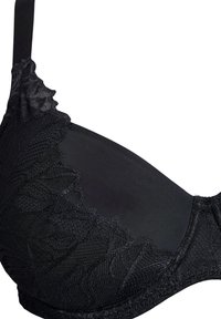 Reggiseno nero con sovrapposizione in pizzo testurizzato e bordi ondulati. Materiale liscio sulla coppa, spalline regolabili e cuciture sottili.
