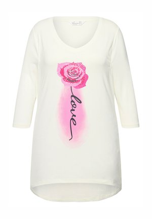 Maglietta a maniche lunghe color crema con scollo a V, caratterizzata da una grafica di una rosa rosa e la parola "love" in corsivo nero sotto di essa. Tessuto morbido.