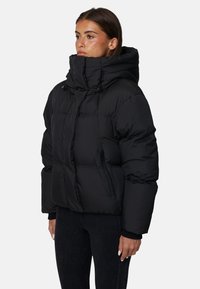 Giacca a vento nera con colletto alto, imbottitura spessa e vestibilità oversized. Presenta una texture liscia e polsini elasticizzati.