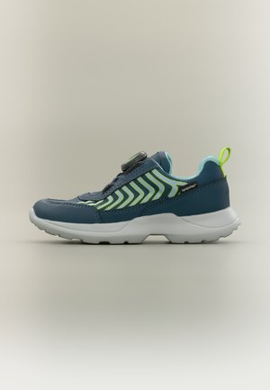 Baskets de sport bleu et vert avec des rayures en zigzag, une fermeture à molette sur le dessus, une semelle blanche et une boucle de tirage vert fluo au talon.