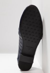 Chaussure en cuir bleu foncé avec un motif croco texturé. La semelle est en caoutchouc, avec une empreinte de logo et une taille 37. Design à talon plat.