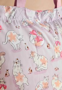 Tessuto rosa chiaro ricoperto da illustrazioni giocose di gatti bianchi con macchie e topi, alcuni con fiocchi. Elementi di design luminosi e fantasiosi.