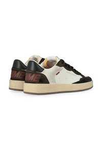 Sneaker caratterizzate da una combinazione di pelle bianca, suede marrone e accenti neri. Suola spessa di colore crema con "CRIME" in rosso sul tallone. Design classico.