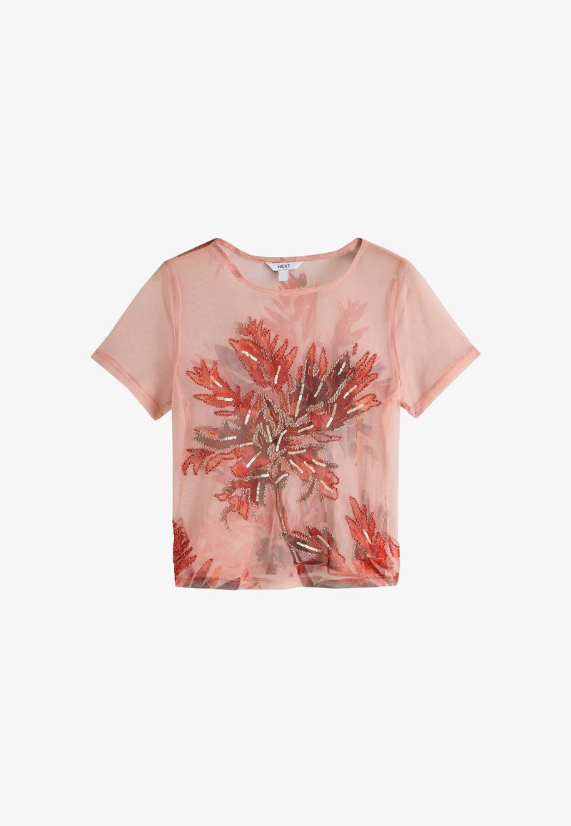 Haut court à manches courtes couleur pêche transparente avec col rond, présentant des motifs de feuilles ornés de sequins rouges et dorés sur le devant.