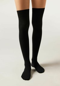 Zwarte kniehoge sokken van ribbelmateriaal. Glad oppervlak, reikt boven de knie, met een aangesloten ontwerp en een ronde teen.