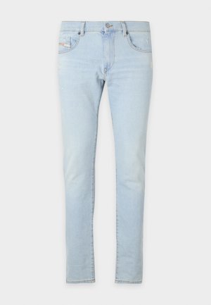 Light blue denim jeans with a slim fit, featuring front and back pockets, and slight distressing on the fabric for texture.