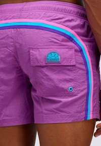 Costumi da bagno viola con vita elastica, strisce laterali blu, rosa e viola, dotati di una tasca sul retro e un'etichetta con logo.