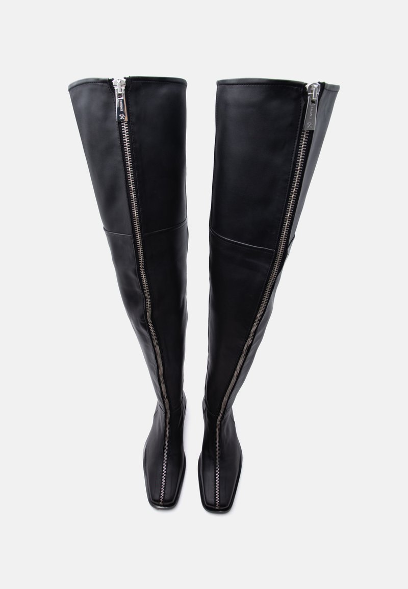 Black thigh-high leather boots with front silver zippers and square toes, standing upright on a plain white background.