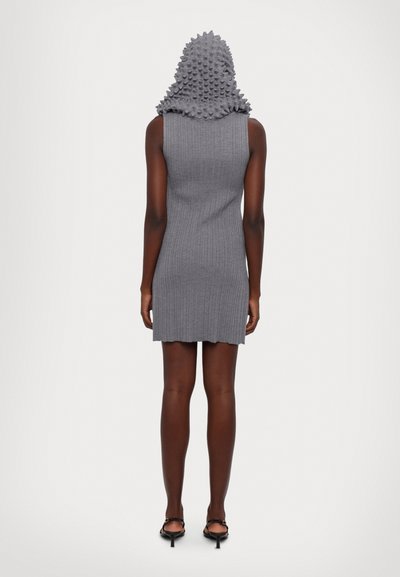 Graues, geripptes Strickkleid mit einer strukturierten, genoppten Kapuze. Das Kleid ist figurbetont mit einem leicht gewellten Saum und wird mit schwarzen Riemchen-Heels kombiniert.