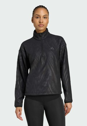 Black fleece pullover with a half-zip collar, featuring a subtle textured pattern and long sleeves. Brand logo visible on the upper left side.