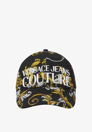 Casquette noire ornée de motifs baroques dorés, avec des grands textes blancs "VERSACE JEANS COUTURE" à l'avant, une visière incurvée et un tissu texturé.
