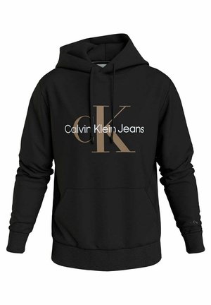 Czarna bluza z kapturem z dużym beżowym logo "CK" i białym napisem "Calvin Klein Jeans" na przodzie, z przednią kieszenią typu kangurek i sznurkami.