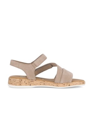 Beige sandaal met open teen, verstelbare enkelriem, gekruiste bandjes en lage sleehak met kurkartige textuur op een witte achtergrond.