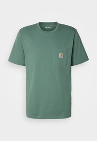 T-shirt in cotone verde con scollatura rotonda, maniche corte, taschino sul petto e una toppa quadrata con logo sulla tasca.