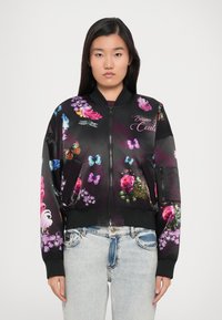 Čierna bomber bunda s živými kvetinovými a motýlími vzormi, so zapínaním na zips, ribbed manžetami a uvoľneným strihom, vyrobená z hladkej tkaniny.