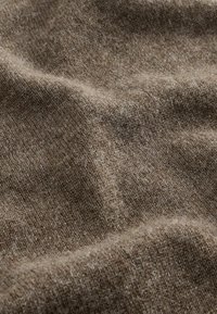 Brauner Wollstoff mit strukturierter Oberfläche, der weiche, feine Fasern und subtile Schattierungsvariationen zeigt, ideal für Kleidungsstücke oder Accessoires.