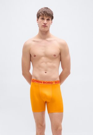 Boxer orange avec une ceinture rouge "BJÖRN BORG", en tissu lisse, avec une coupe ajustée et une longueur mi-cuisse.