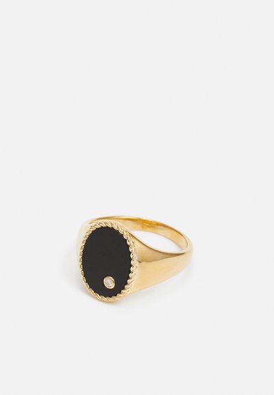 Gold ring featuring an oval black center with a textured rope edge and a small diamond accent. Smooth finish, modern design.