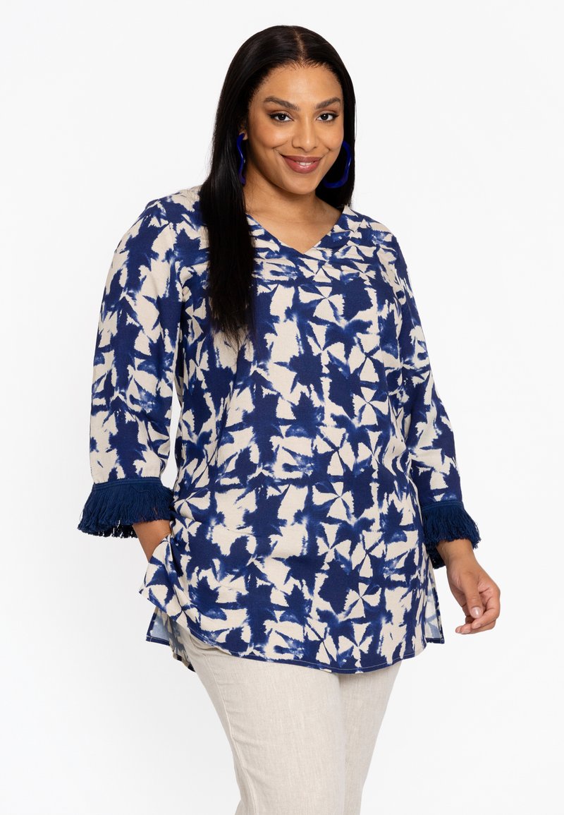 Blauw en crèmekleurige blouse met een bloemenpatroon, V-hals en driekwart mouwen met marineblauwe franjes op de manchet.