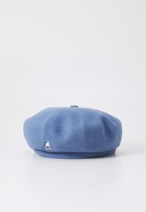 Berretto di lana blu con forma arrotondata, texture morbida e piccolo logo di un canguro bianco sulla parte anteriore. Design semplice senza motivi.