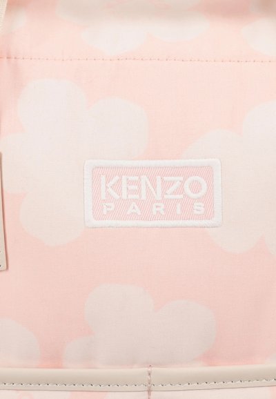 Sac rose avec un motif floral, une étiquette brodée "KENZO PARIS" en blanc, et un tissu lisse texturé avec des accents beiges.