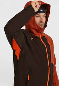 Bruine en oranje jas met een rits aan de voorkant, mesh-accenten, verstelbare capuchon en een slim fit ontwerp. Bevat levendige details en zakken.