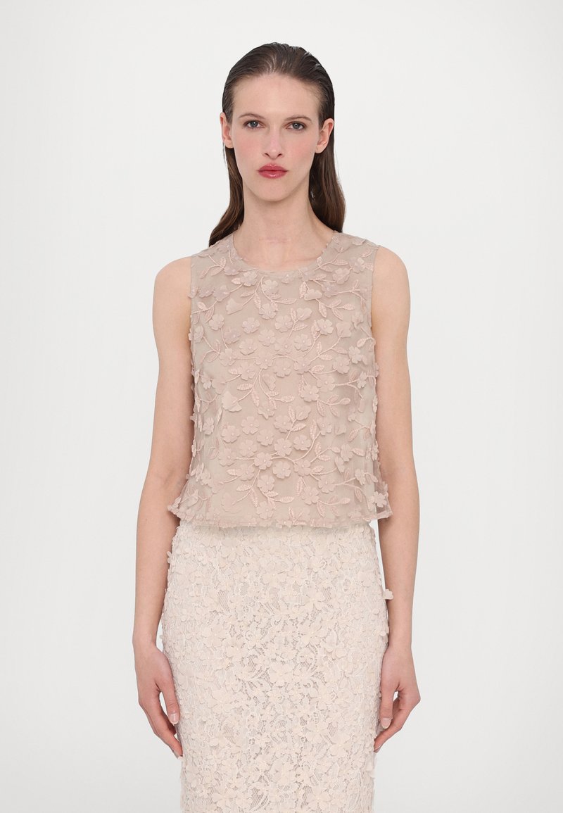 Beige floral lace top with layered texture, round neckline, and sleeveless design, paired with a matching lace skirt.