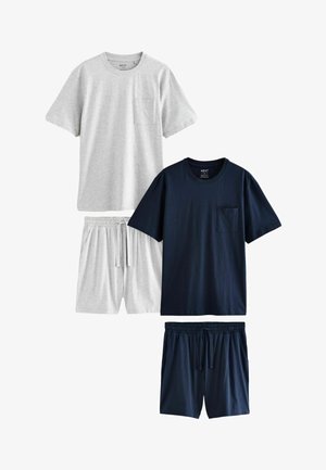 Dve bavlnené tričká v svetlosivej a námorníckej modrej farbe, každé s vreckom na hrudi, skombinované s elastickými šortkami v rovnakých farbách.