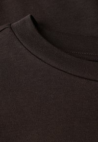 Bruine katoenen t-shirtstof met een geribde ronde hals, met een zachte textuur en consistente kleur. Geen zichtbare patronen of graphics.