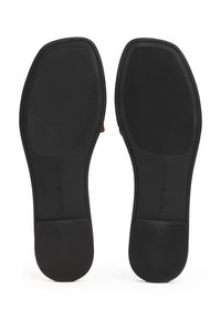 Paire de semelles de chaussures noires avec une adhérence texturée et une forme rectangulaire, vues du dessous.